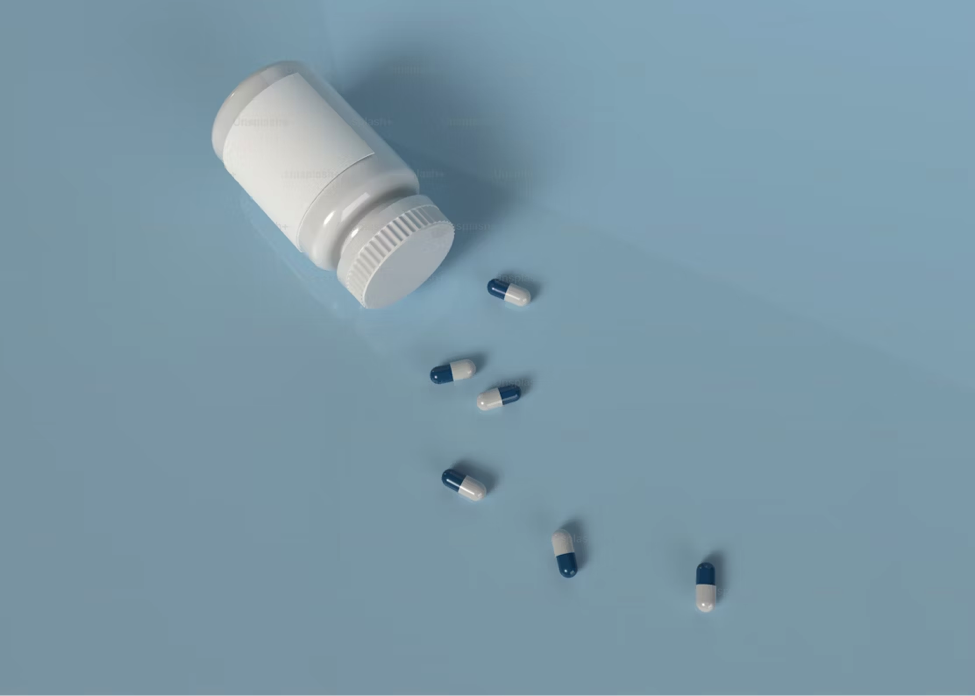 OTC medication bottle on Side with spilled blue and whitepills